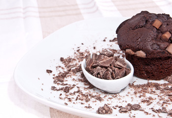 Brown muffin with chocolate on a plate