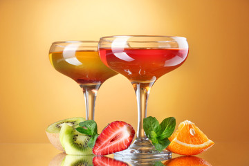 fruit jelly in glasses and fruits on yellow background