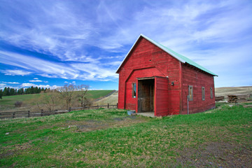 Red shed, green grass, blue sky.