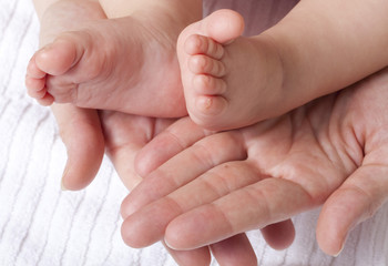 parent hands embracing baby feet - 41230675