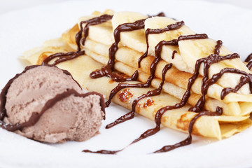 Thin pancakes with banana, ice cream and chocolate