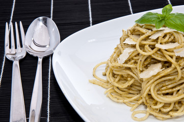 Heap of spaghetti with fresh pesto on dark background