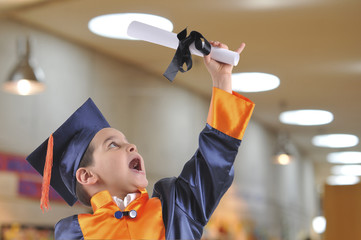 Elementary boy proudly wearing his graduation cap and gown