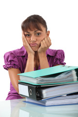 Bored businesswoman with a pile of folders