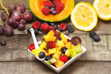 greedy fruit salad with red fruits on wood