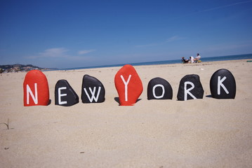 New York, word on stones with sand background