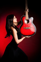 Carmen beautiful woman with guitar on dark background