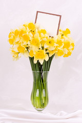 Beautiful spring flowers in a glass vase with banner add