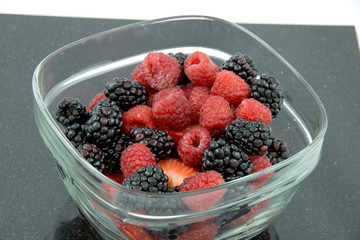 Fresh blackberries and raspberries in glass bowl