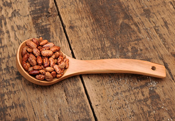 beans in wooden spoon on wooden table