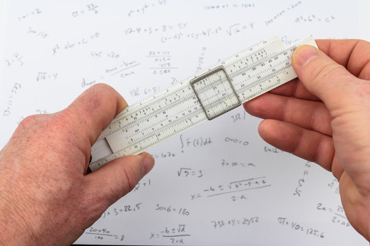person calculating on a slide rule