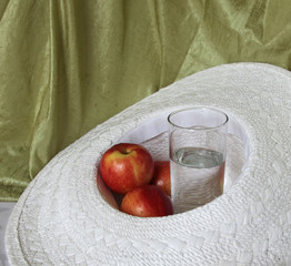 Glass of water and apples in a hat