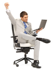 young businessman sitting in chair with laptop