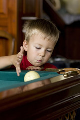 A child plays billiards - obrazy, fototapety, plakaty