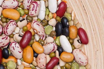 Legumes and cereales close up in wooden plate