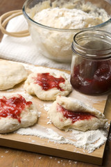 Dough with marmelade on wooden board