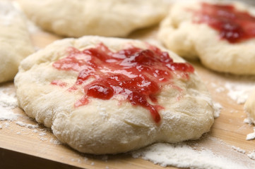 Dough with marmelade on wooden board