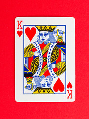 Old playing card (king) isolated on a red background