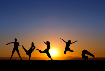 silhouette of gymnasts in sunset