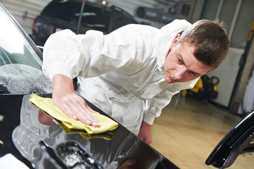 mechanic repairing and polishing car headlight