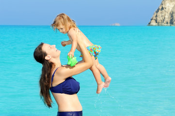 Fototapeta na wymiar Happy child with her mother on the beach