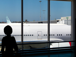 Child watching aircraft in an airport terminal