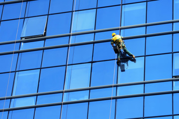 Washer wash the windows of modern skyscraper