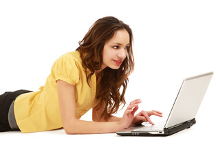 A young girl with a laptop lying on the floor