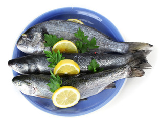 Fresh fishes with lemon and parsley on plate isolated on white