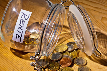 Glas mit Münzen. Aufschrift Rente / Pension