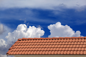 Roof tiles and blue sky with clouds