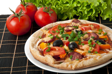 Closeup of pizza with tomatoes, cheese, black olives and peppers