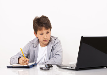 Young boy taking notes