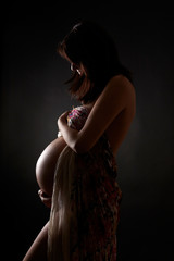 Pregnant woman over dark background