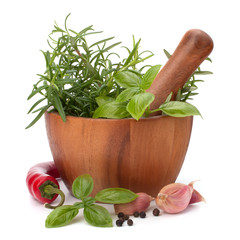 fresh flavoring herbs and spices in wooden mortar