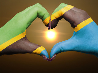 Heart and love gesture by hands colored in tanzania flag during - obrazy, fototapety, plakaty