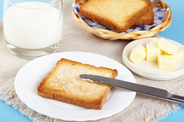 Breakfast. Glass with milk and toasts with butter