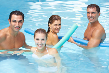 Freunde mit Schwimmnudeln im Pool