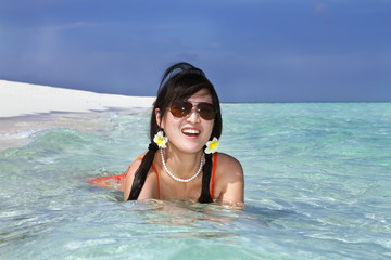 Beautiful fashion asian girl playing water in Maldive beach near