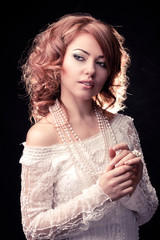portrait of a woman in a beige dress an black background