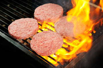 raw Beef burgers being cooked