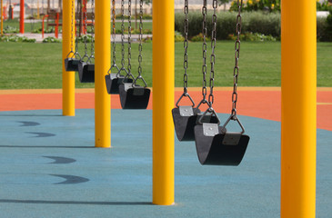 A row of swings in a park near a sea side at  Bahrain