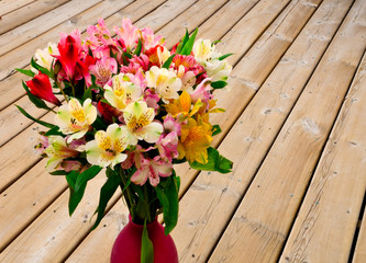 colorful flower bouquet arrangement in vase on a wooden surface