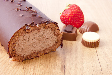 pastel de chocolate sobre la mesa con fresas y bombones