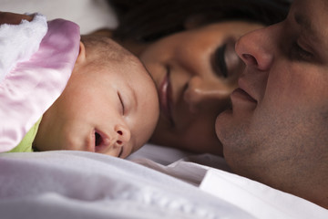 Mixed Race Young Family Laying with Newborn Baby