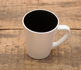 An empty cup of coffee on a wooden table.