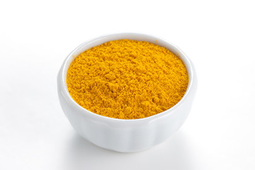 Curry ground (Madras Curry) in a white bowl on white background.
