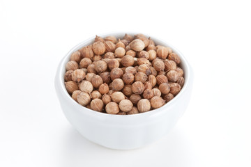 Coriander Seeds (Coriandrum sativum) in a white bowl on white ba