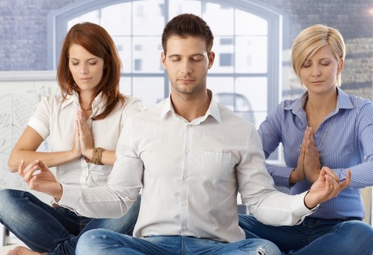 Office workers meditating at work