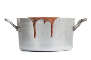 old aluminum pot with melted chocolate, isolated on white